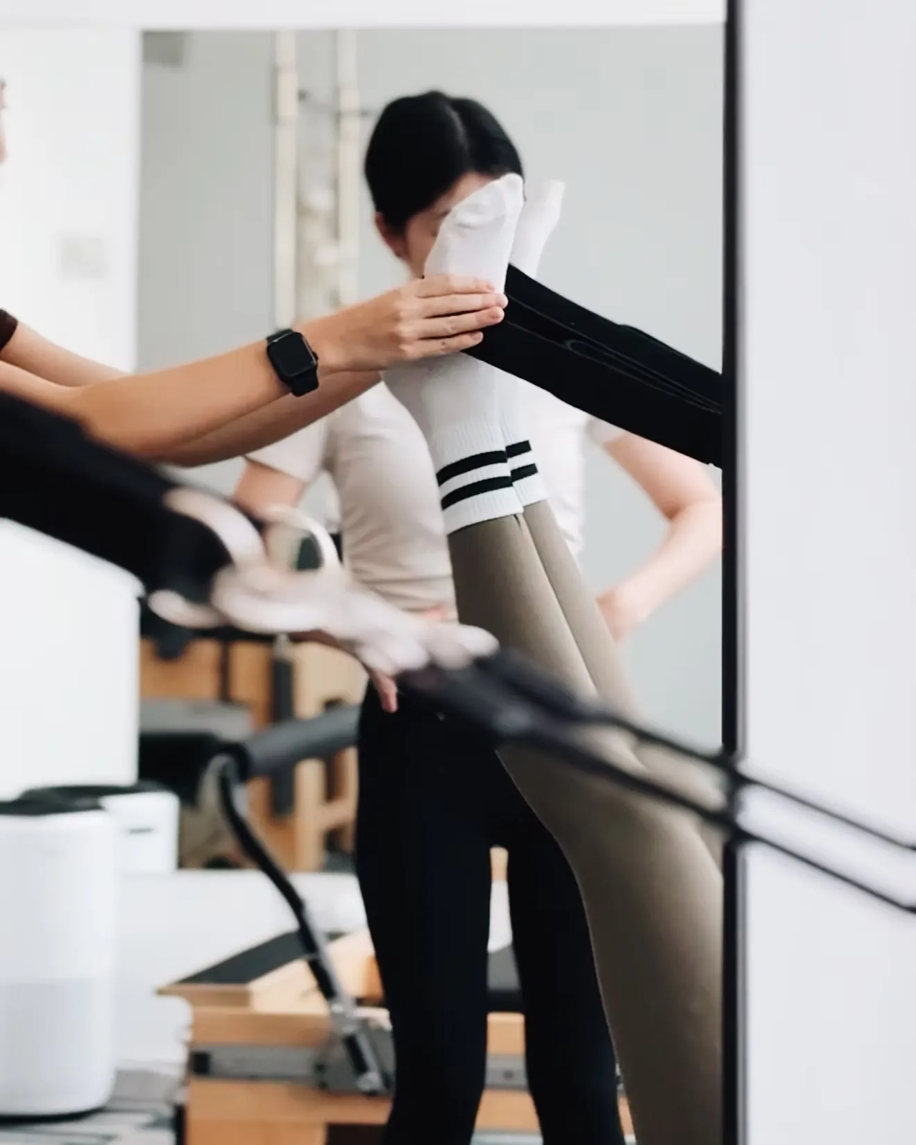 Instructor guiding a client through a Pilates movement